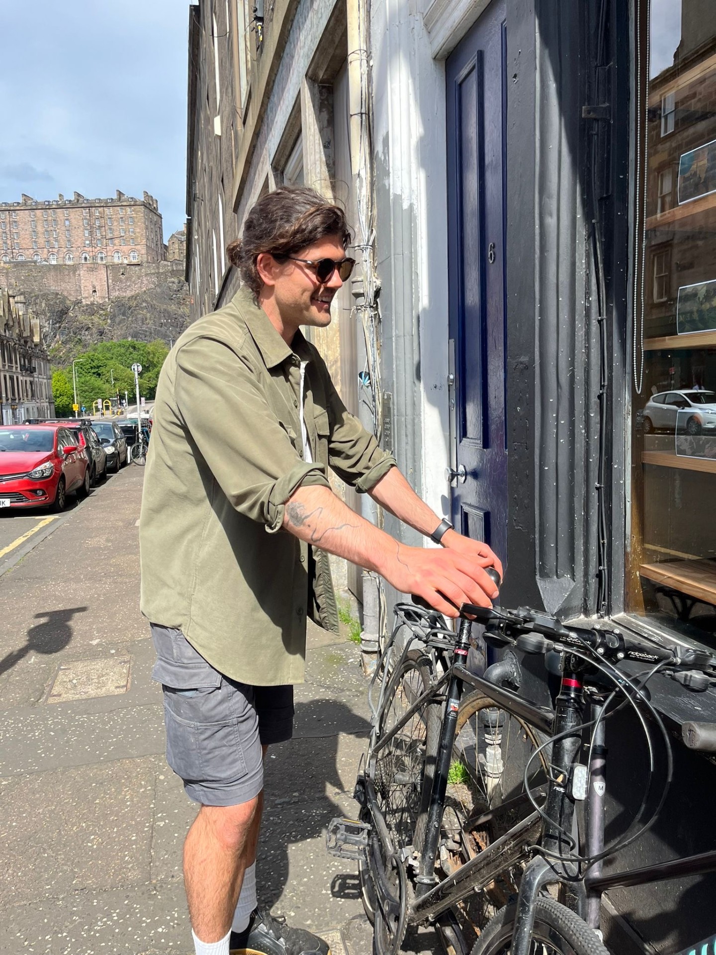 Joe outside his door in Edinburgh, the castle in the background